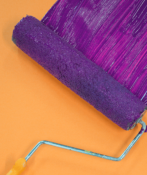 Purple paint roller on orange background