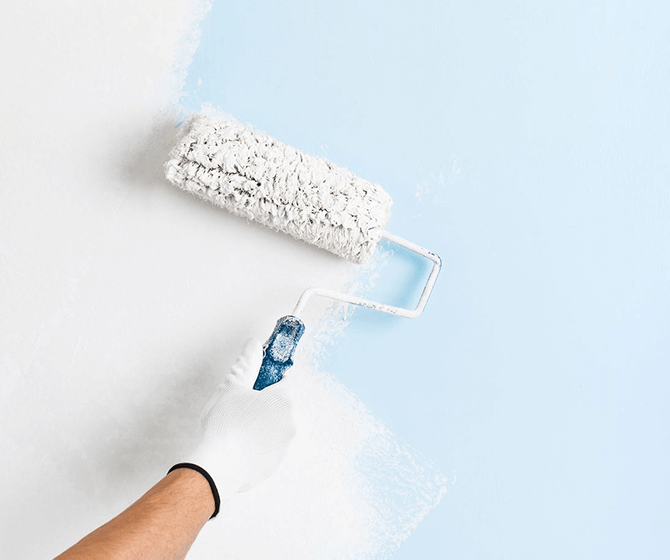 White paint roller on light blue background