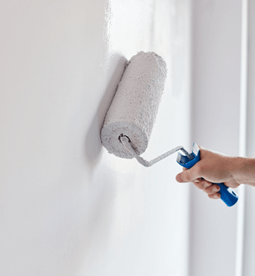 White paint roller on white wall